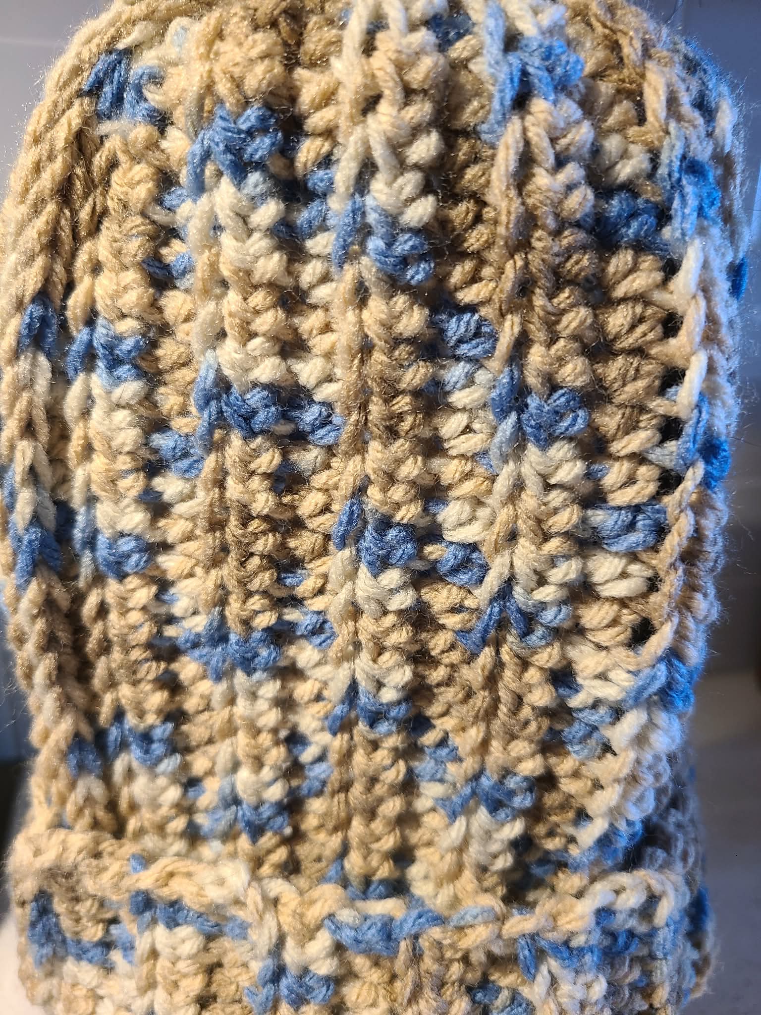 Close-up of a crocheted fabric with blue and beige pattern