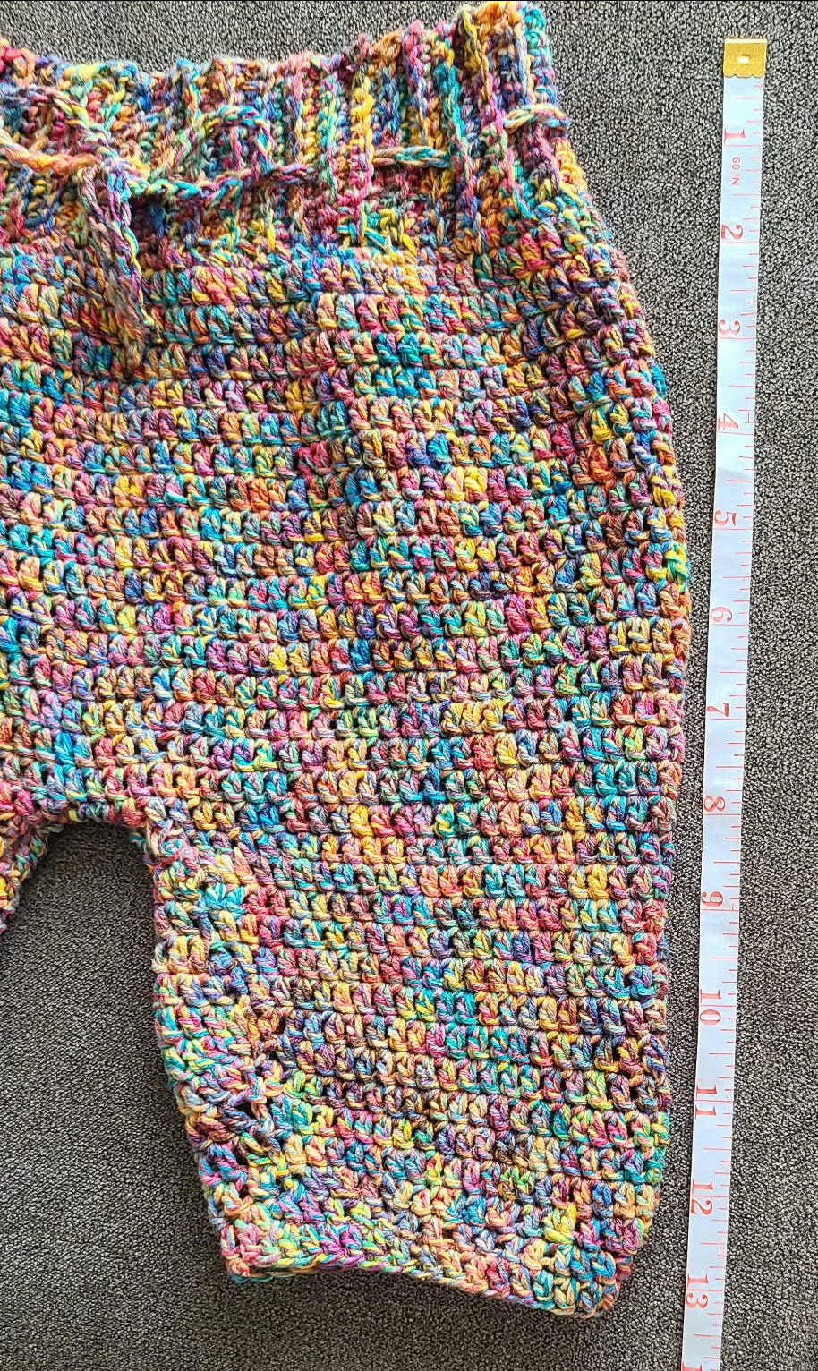 Multicolored crocheted fabric on a gray surface 