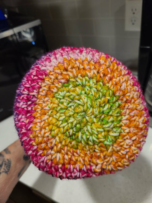 Top view of colorful crocheted baby beanie before pompom added
